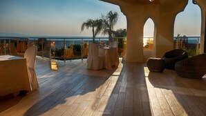 A terrace with a table and chairs, overlooking a body of water. - Hotel Residence Arcobaleno (Palmi)