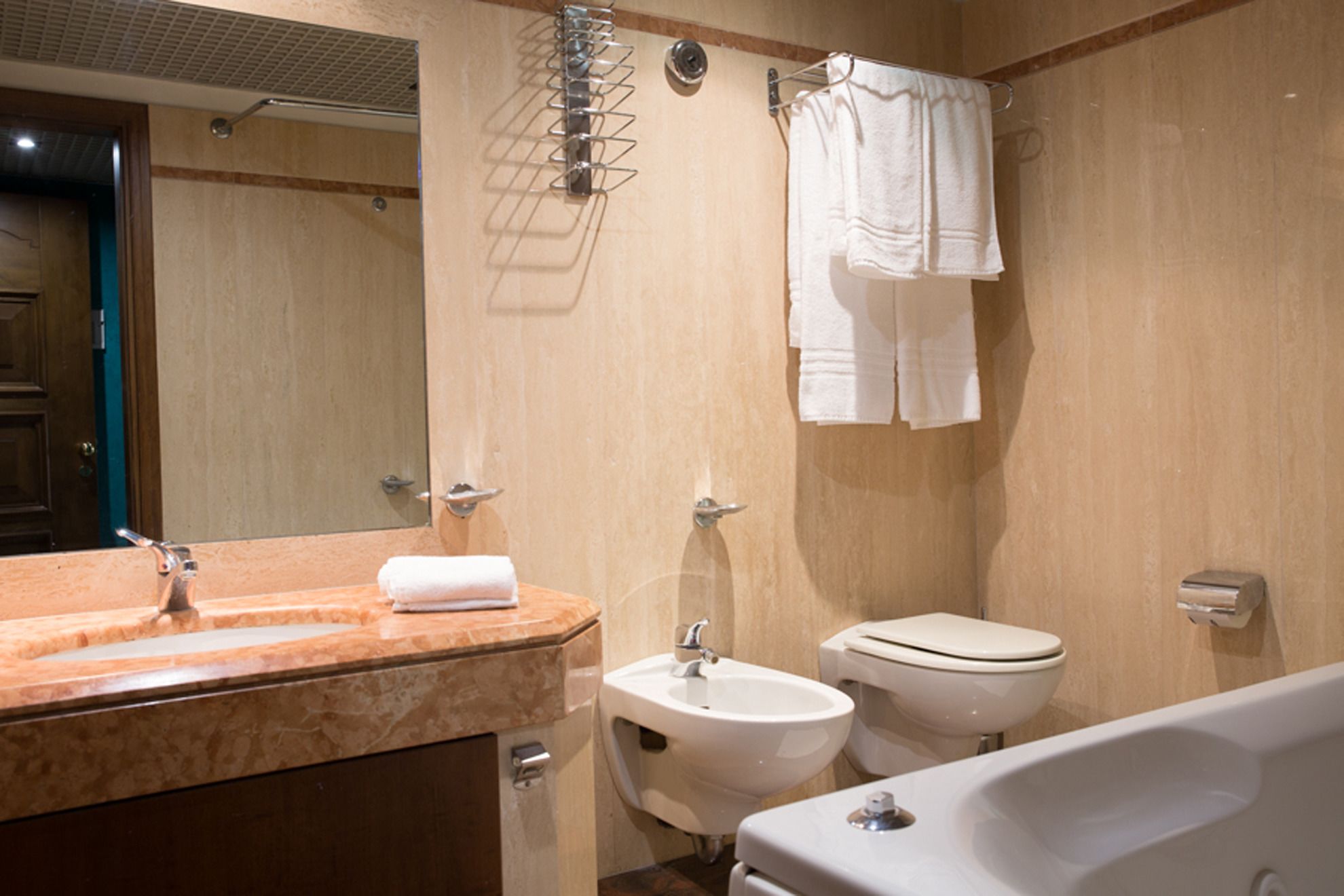 Um banheiro com pia de mármore, pia de pedestal, vaso sanitário e banheira.