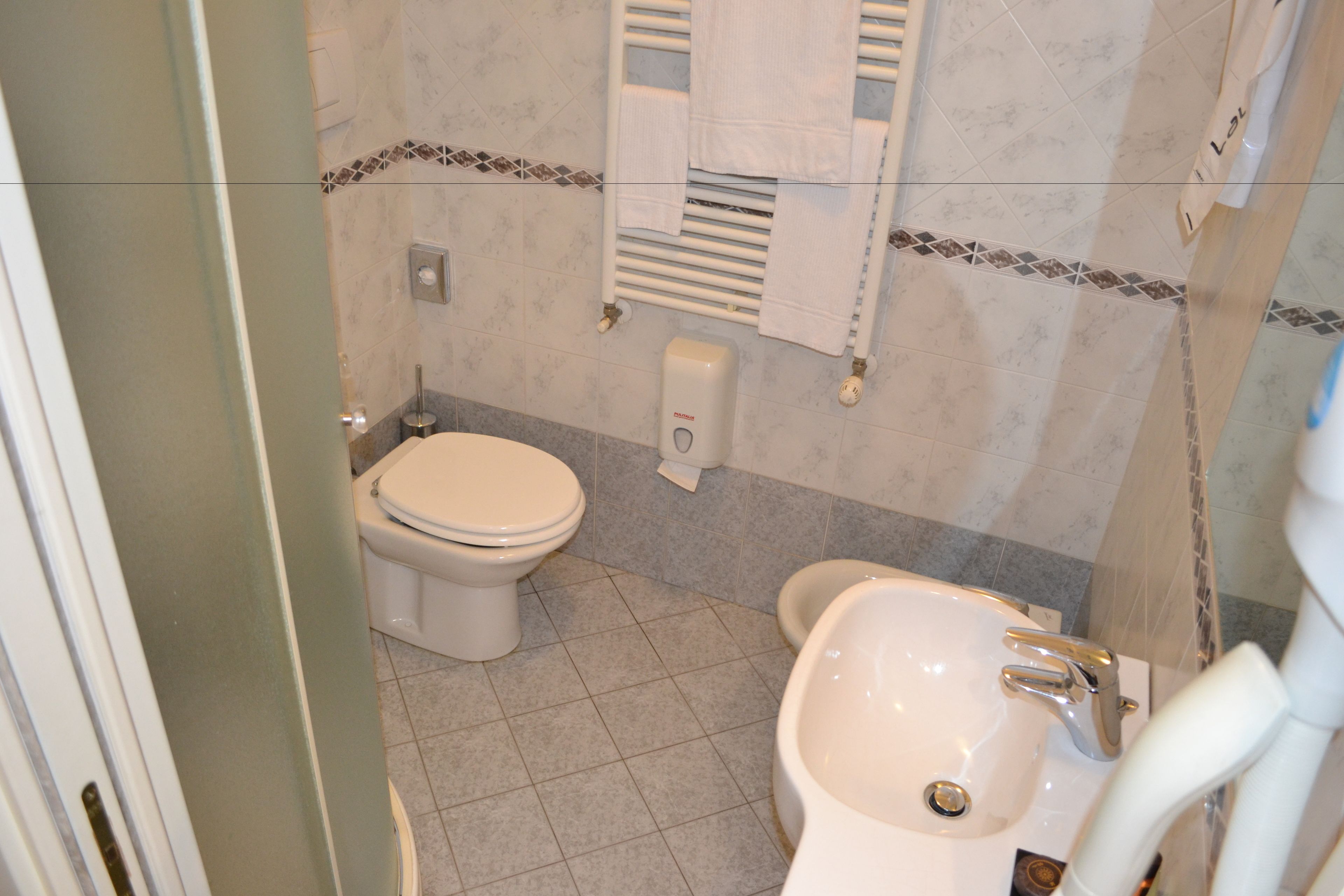 A bathroom with a toilet, bidet, and sink.