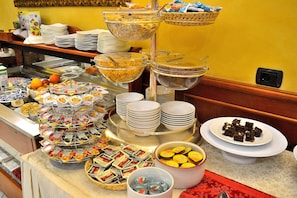 A buffet with various food items and a coffee station.