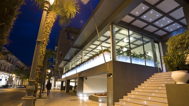 A modern building with a glass facade, a staircase, and a well-lit entrance area. - Palazzo Virgilio (Brindisi)