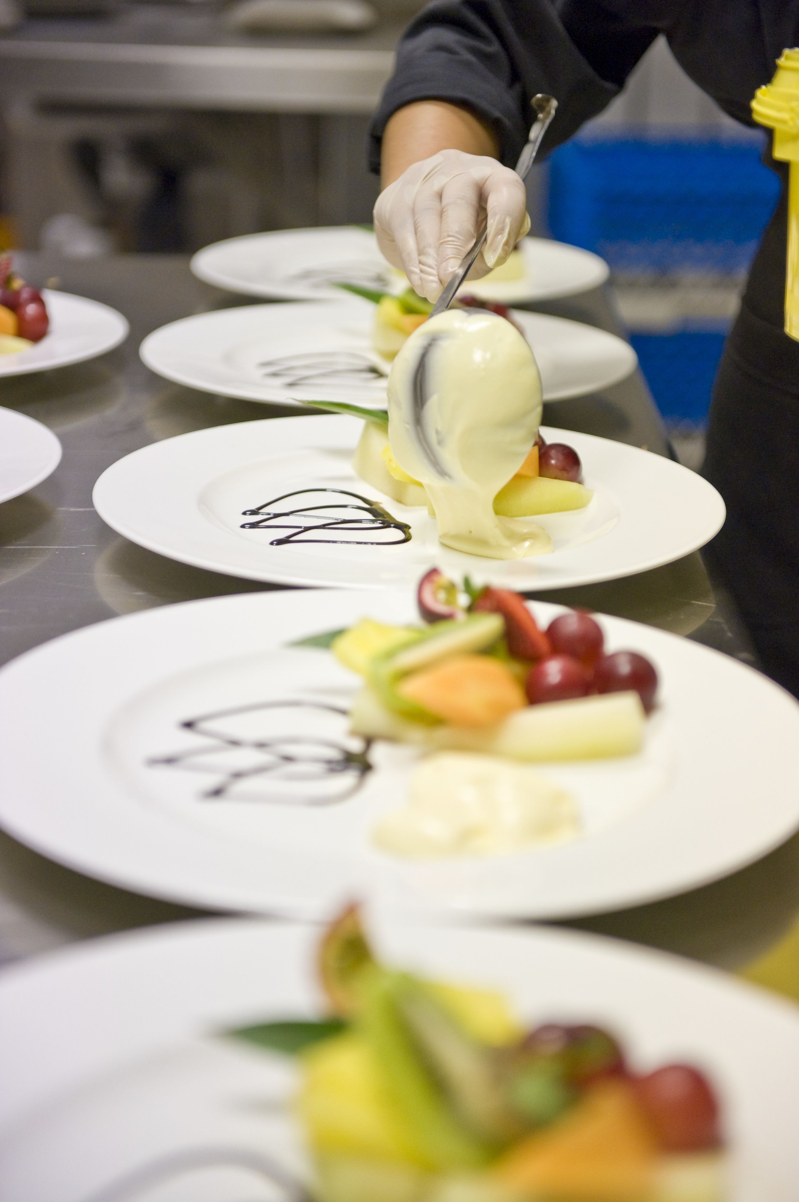 A person serving a dessert on a white plate with a spoon.