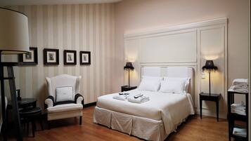 Ein Hotelzimmer mit einem großen Bett, einem Sessel, einem Schreibtisch und einem Oberlicht.