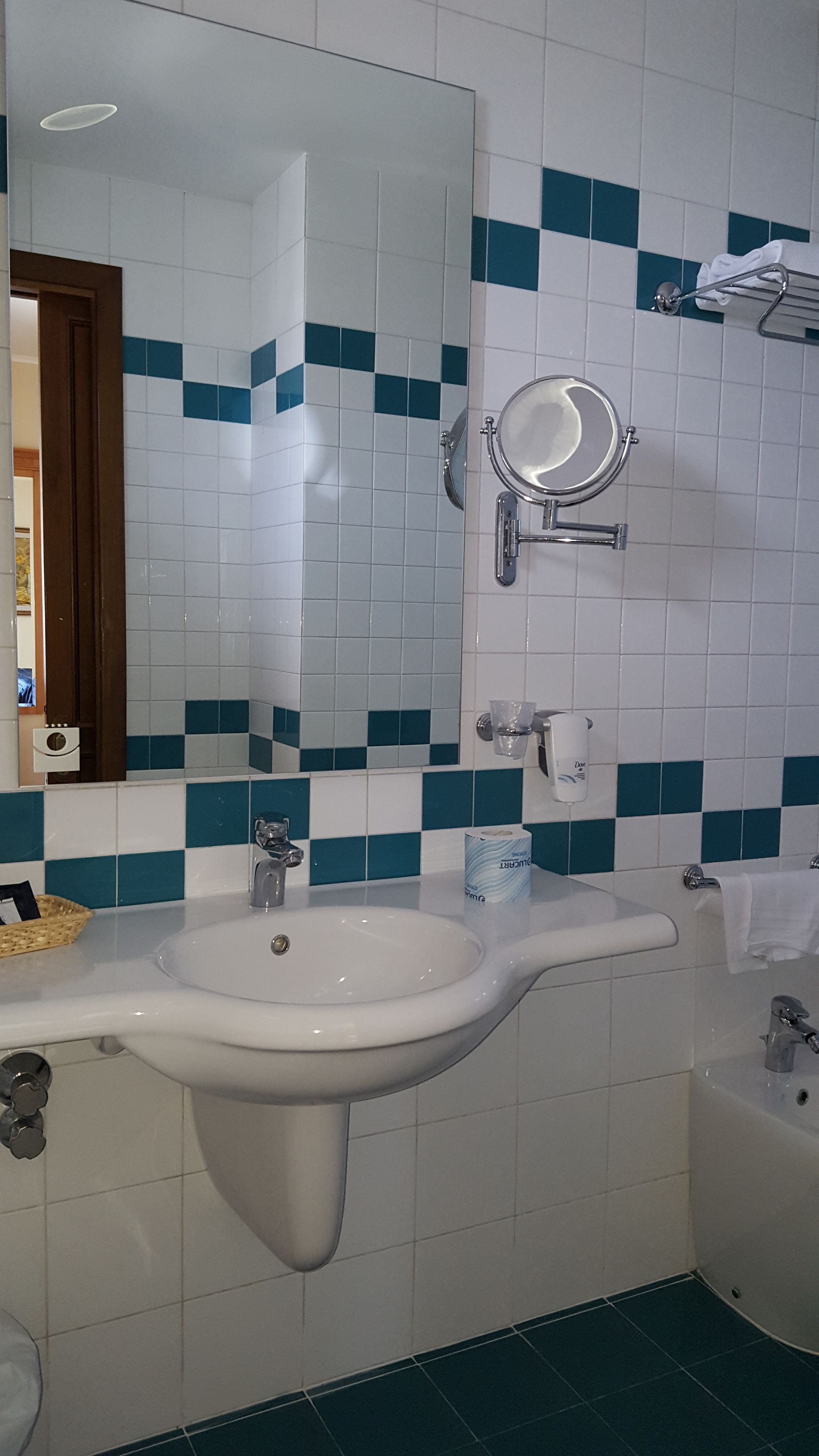 A bathroom with a white sink, a mirror, and a bathtub.