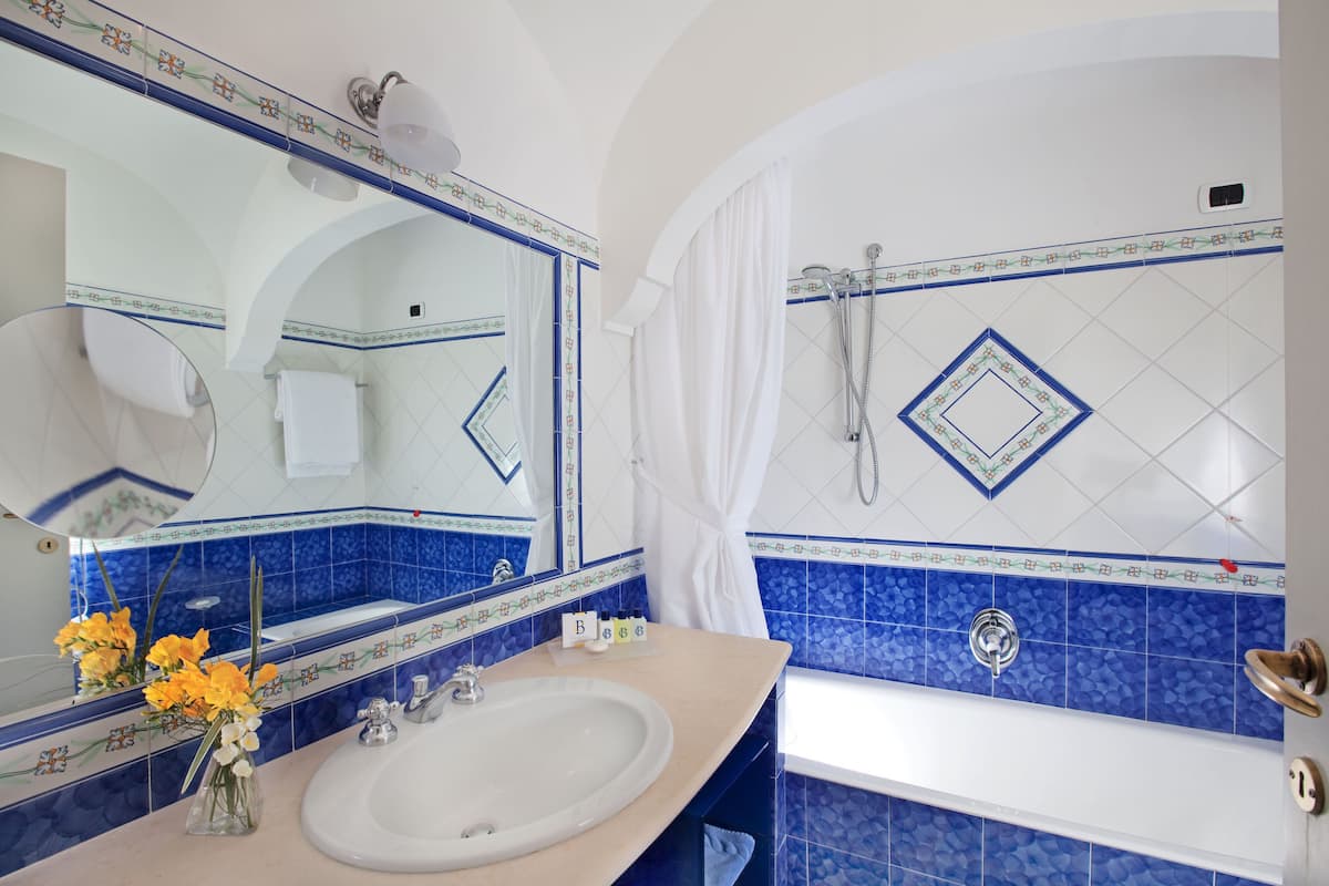 deluxe double room | bathroom | combined shower/bathtub, free toiletries, hair dryer, slippers
