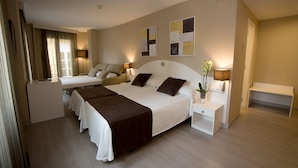 Een hotelkamer met een groot bed, twee nachtkastjes, een bureau en een stoel.