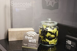 A sign for free wifi and a glass jar filled with yellow and black items, likely toiletries, in a hotel setting. -  Hotel Torico Plaza (Teruel)