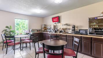 A restaurant with a bar area, seating, and a television displaying 'Free Wi-Fi All Rooms'.