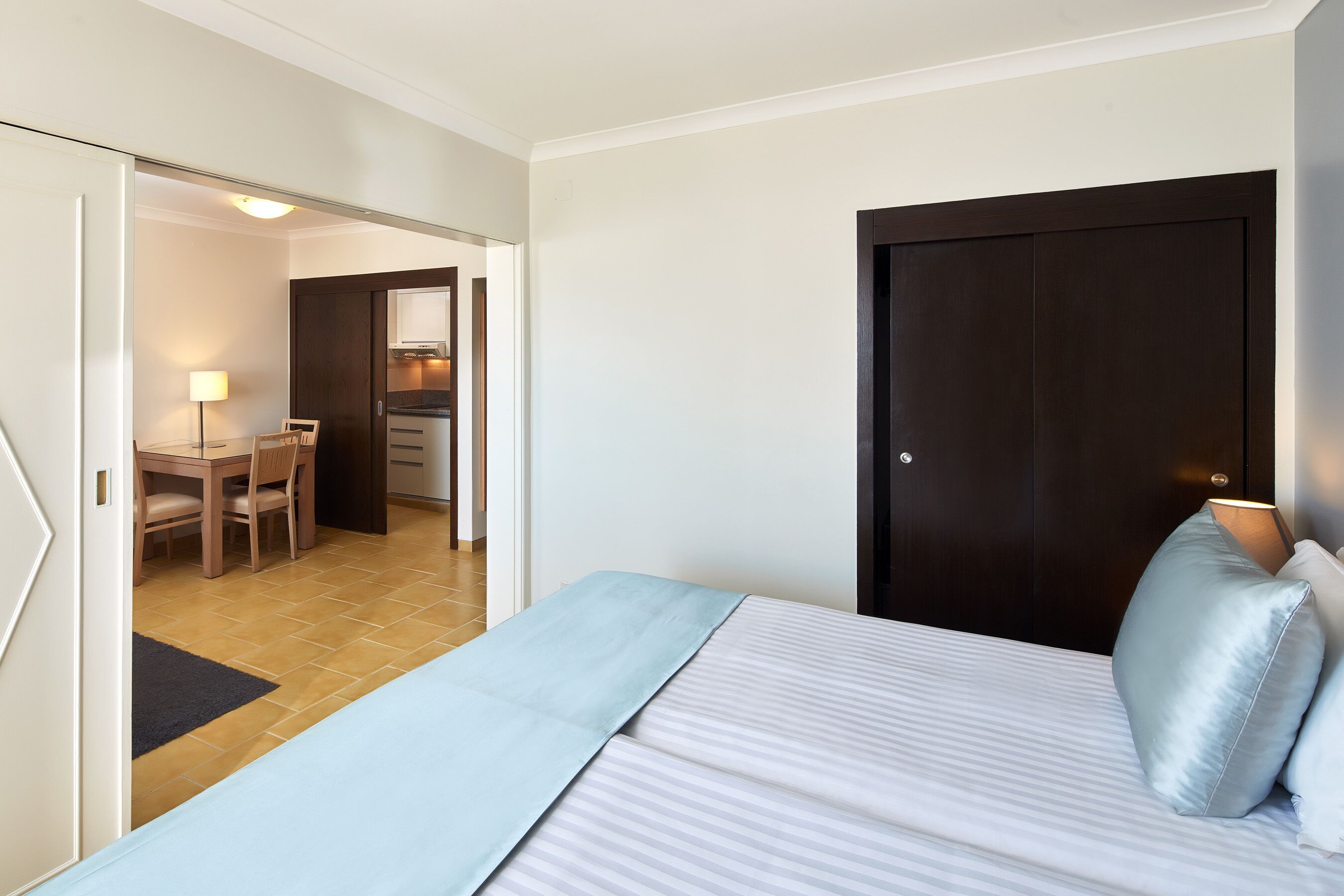 A hotel room with a bed, a desk, and a chair.