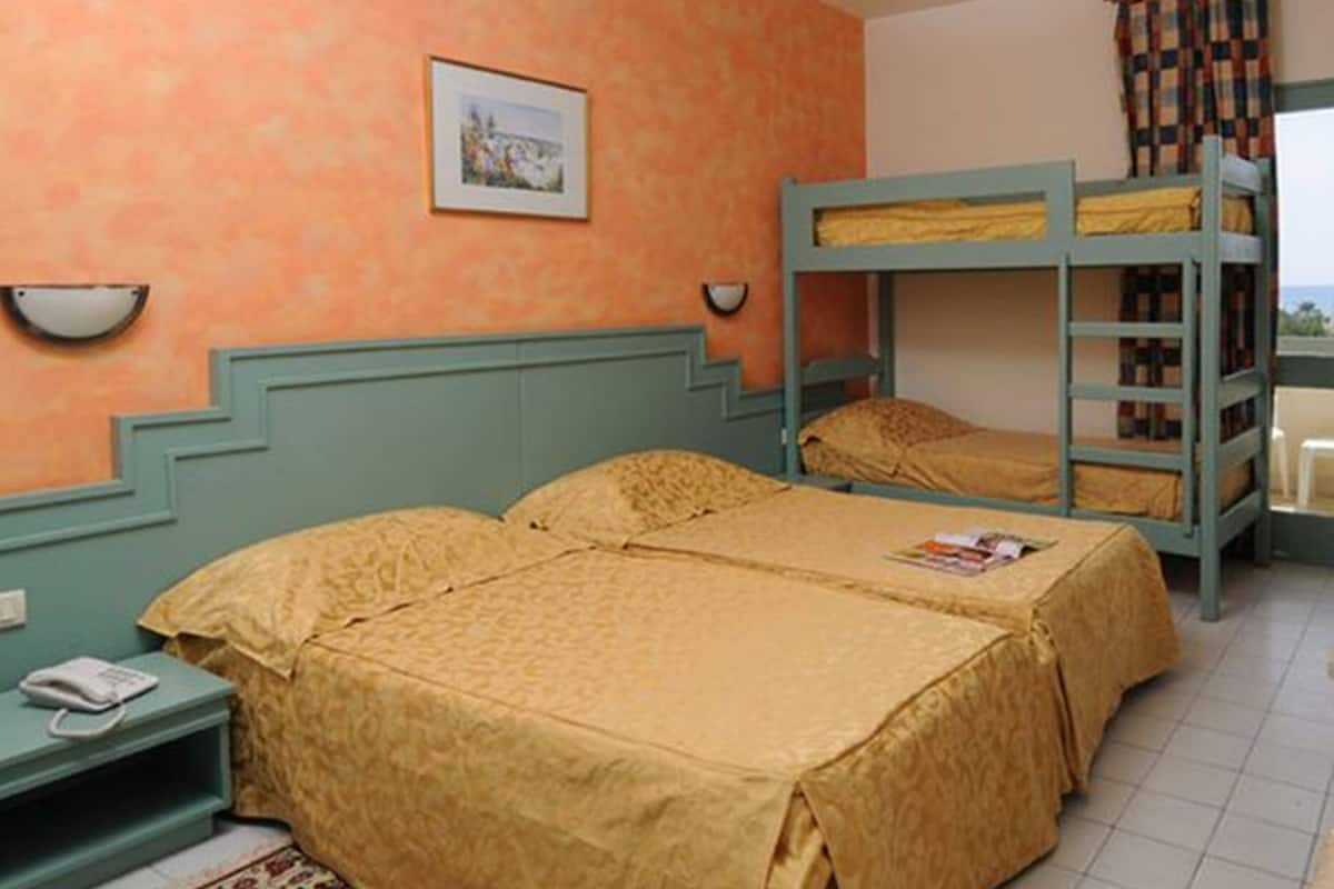 Una habitación con dos camas, un teléfono y un cuadro en la pared.