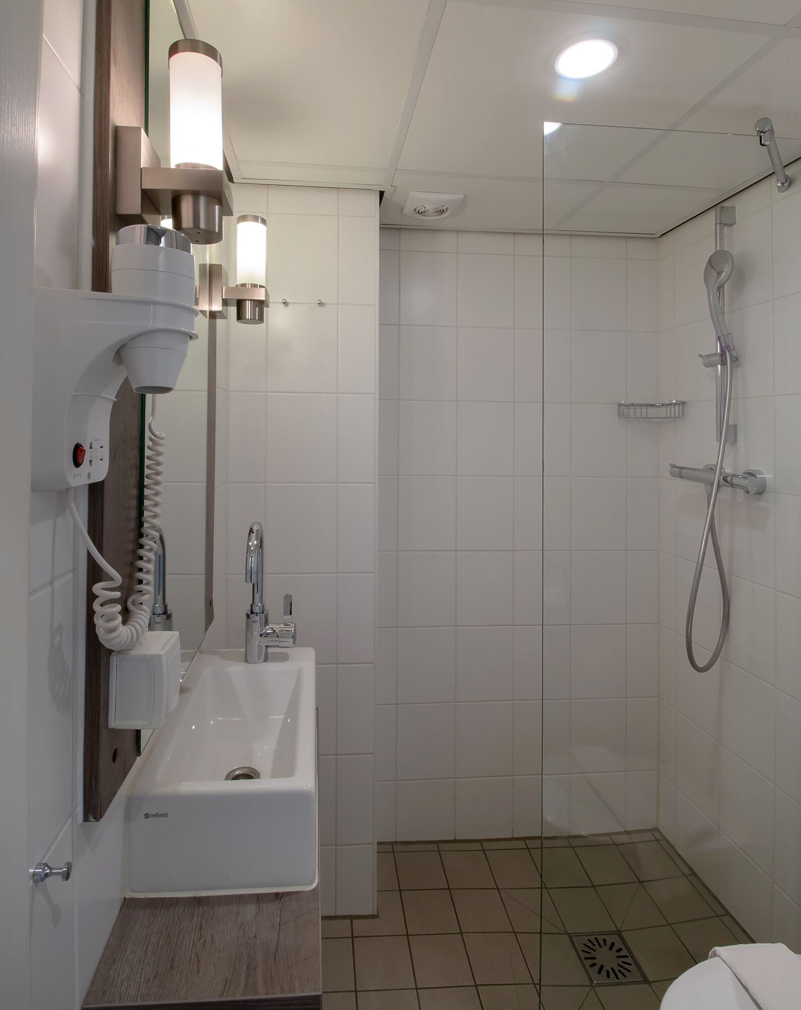 Ein modernes Badezimmer mit Waschbecken, Spiegel und Dusche.
