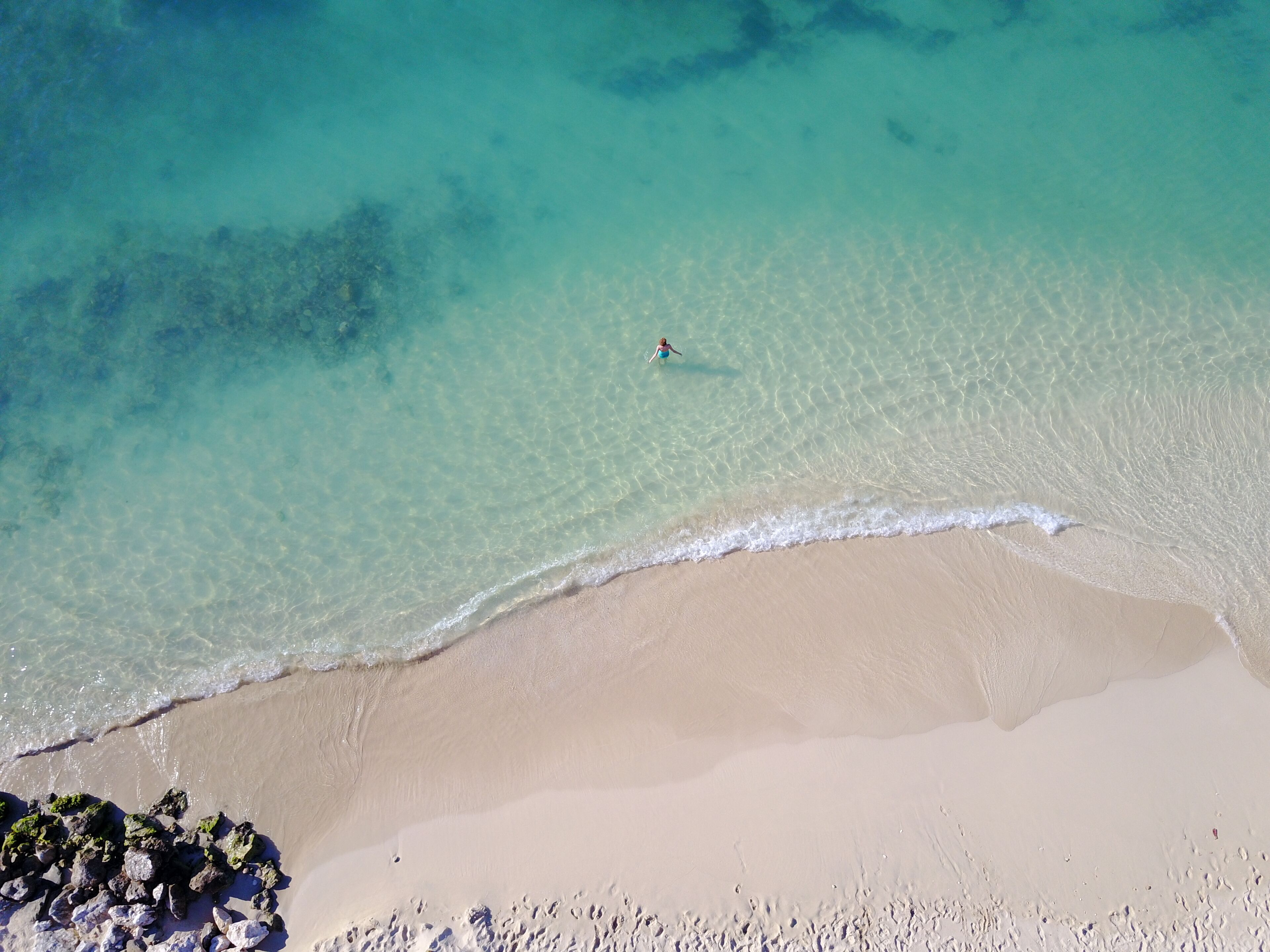 A beach with clear turquoise water and a sandy shore.
