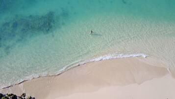 A beach with clear turquoise water and a sandy shore.