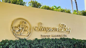 A resort sign with the name 'Sunny Bay' and 'Resort Marina & Spa' indicating a beachfront location.