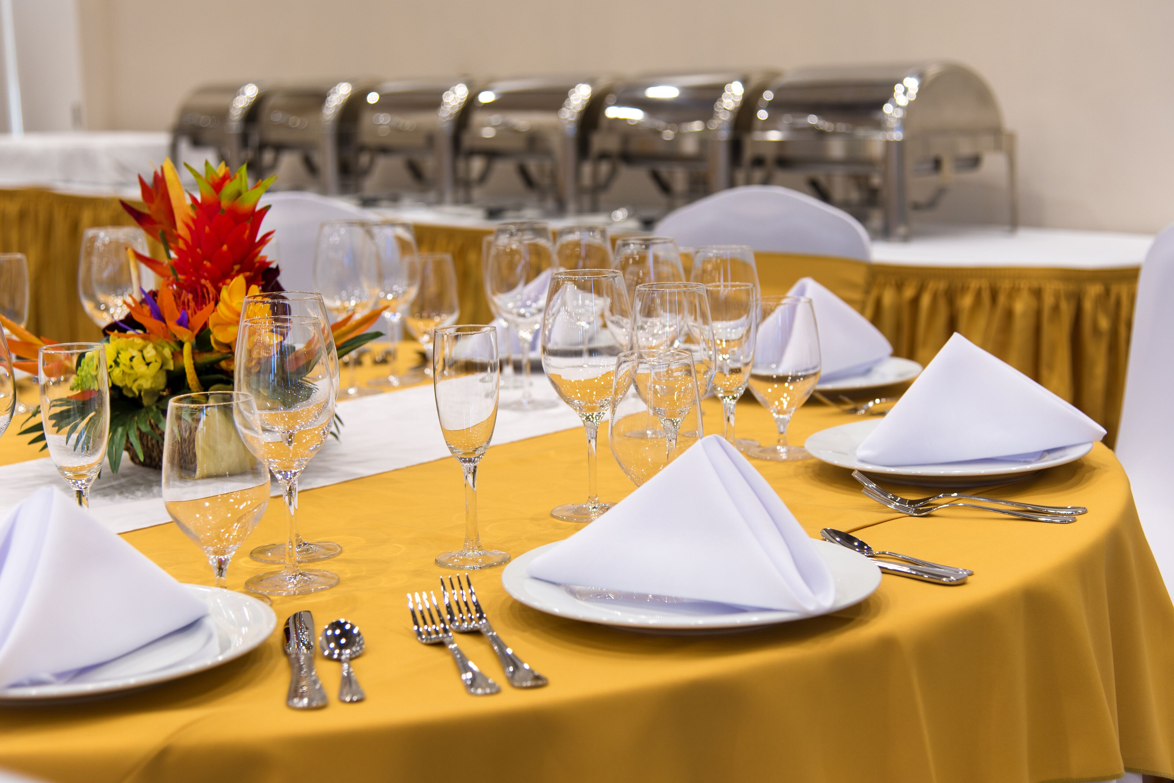 Une table dressée pour un dîner formel, avec de nombreux verres à vin, des assiettes et des couverts.