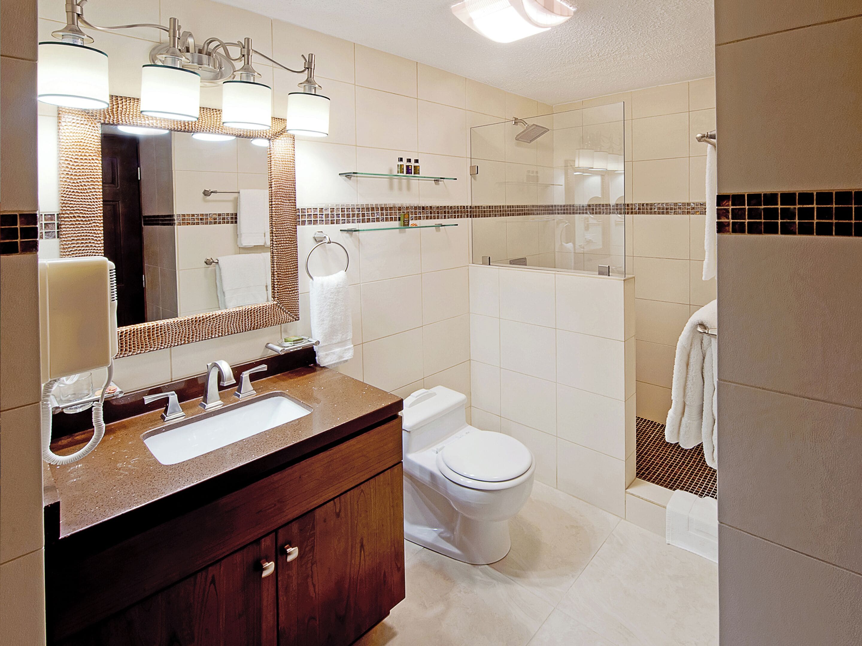 Une salle de bain moderne avec un meuble-lavabo en bois, un grand miroir, une douche en verre et des toilettes blanches.