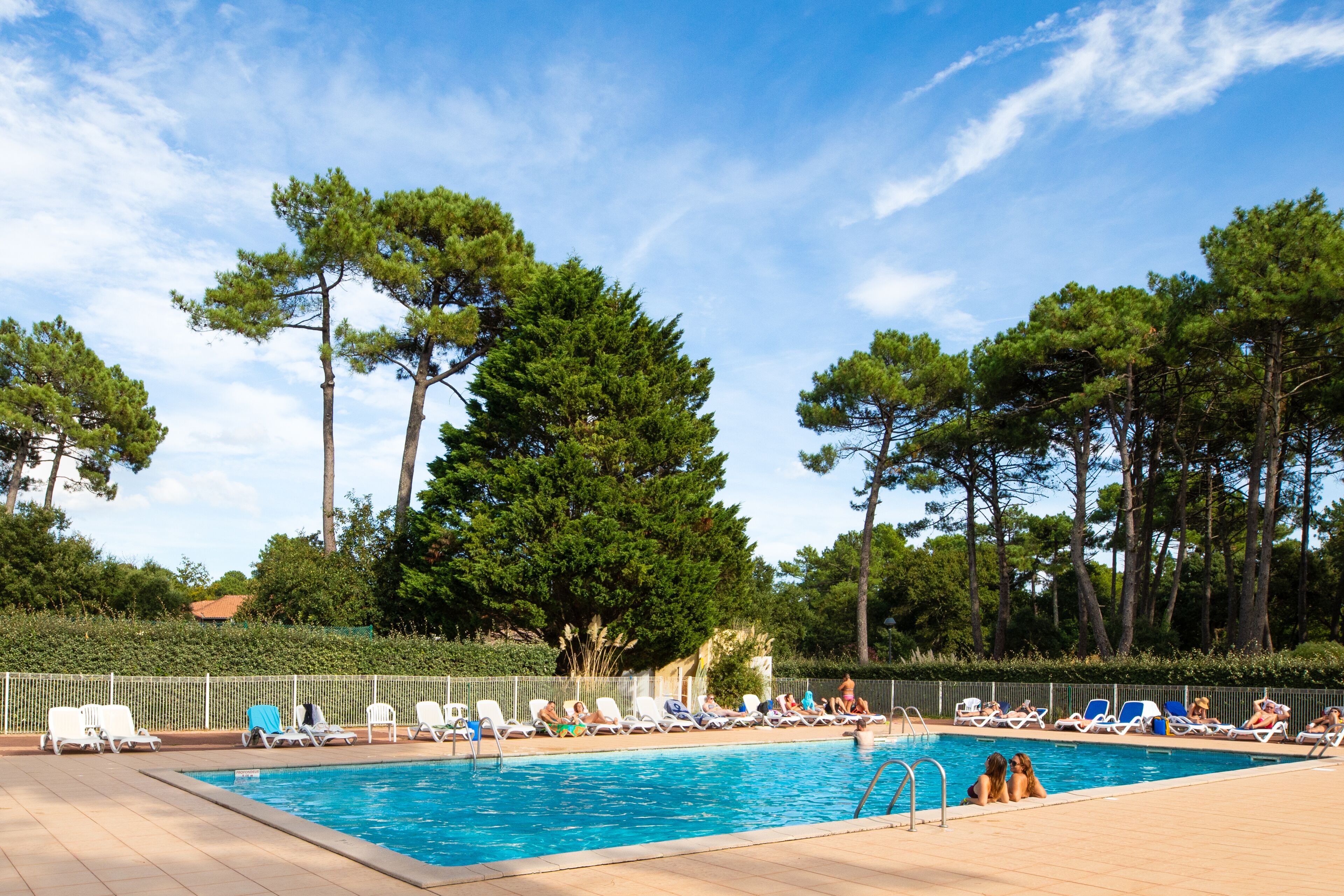 حمّام سباحة خارجي، مظلات على حمّام السباحة، مقاعد للتشمس