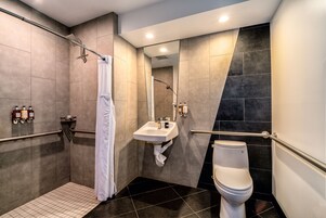 A modern bathroom with a walk-in shower, a sink, and a toilet.