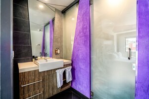 Een moderne badkamer met een grote spiegel, twee wastafels en een douche.
