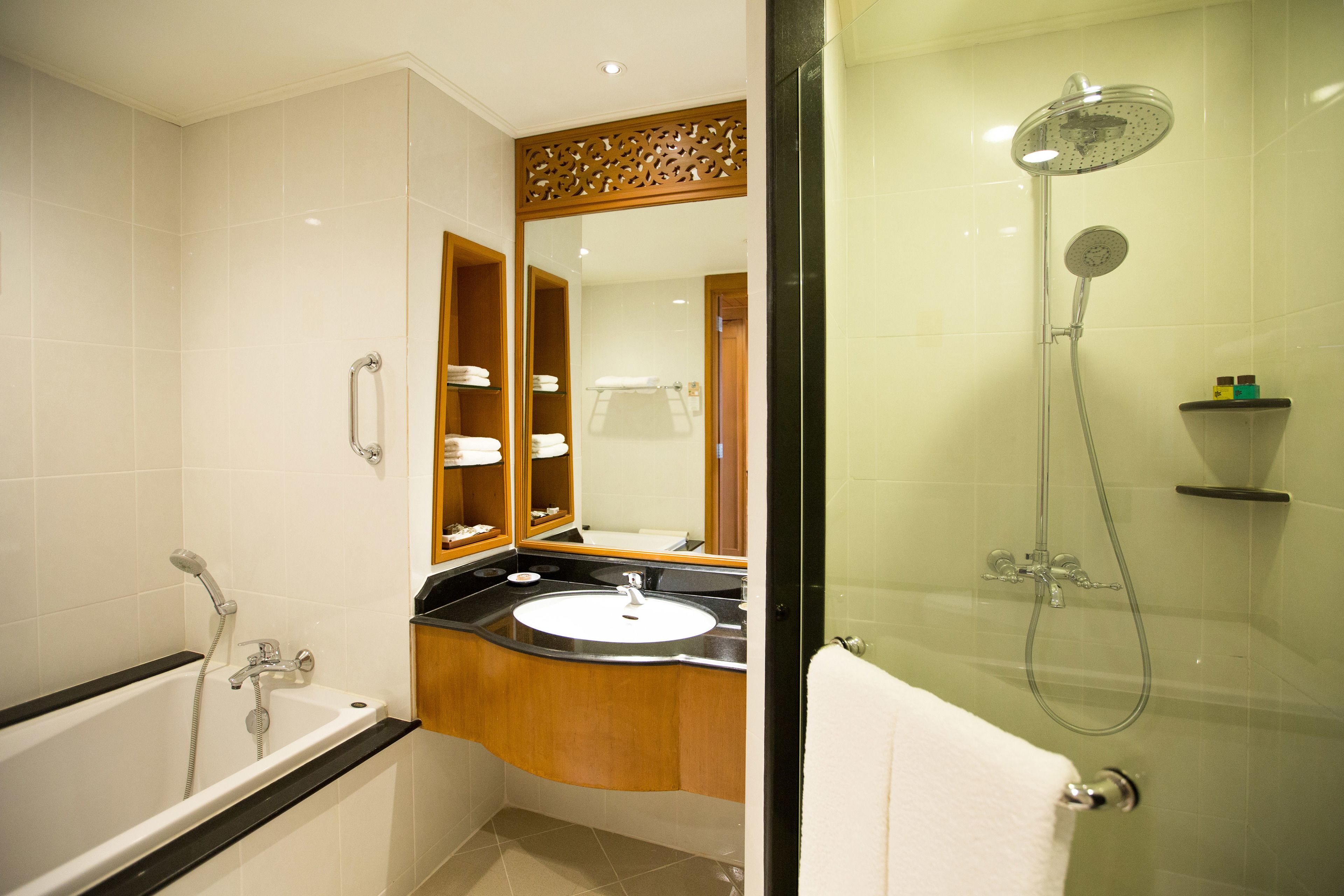 Un baño moderno con bañera, lavamanos y ducha con mampara de vidrio.