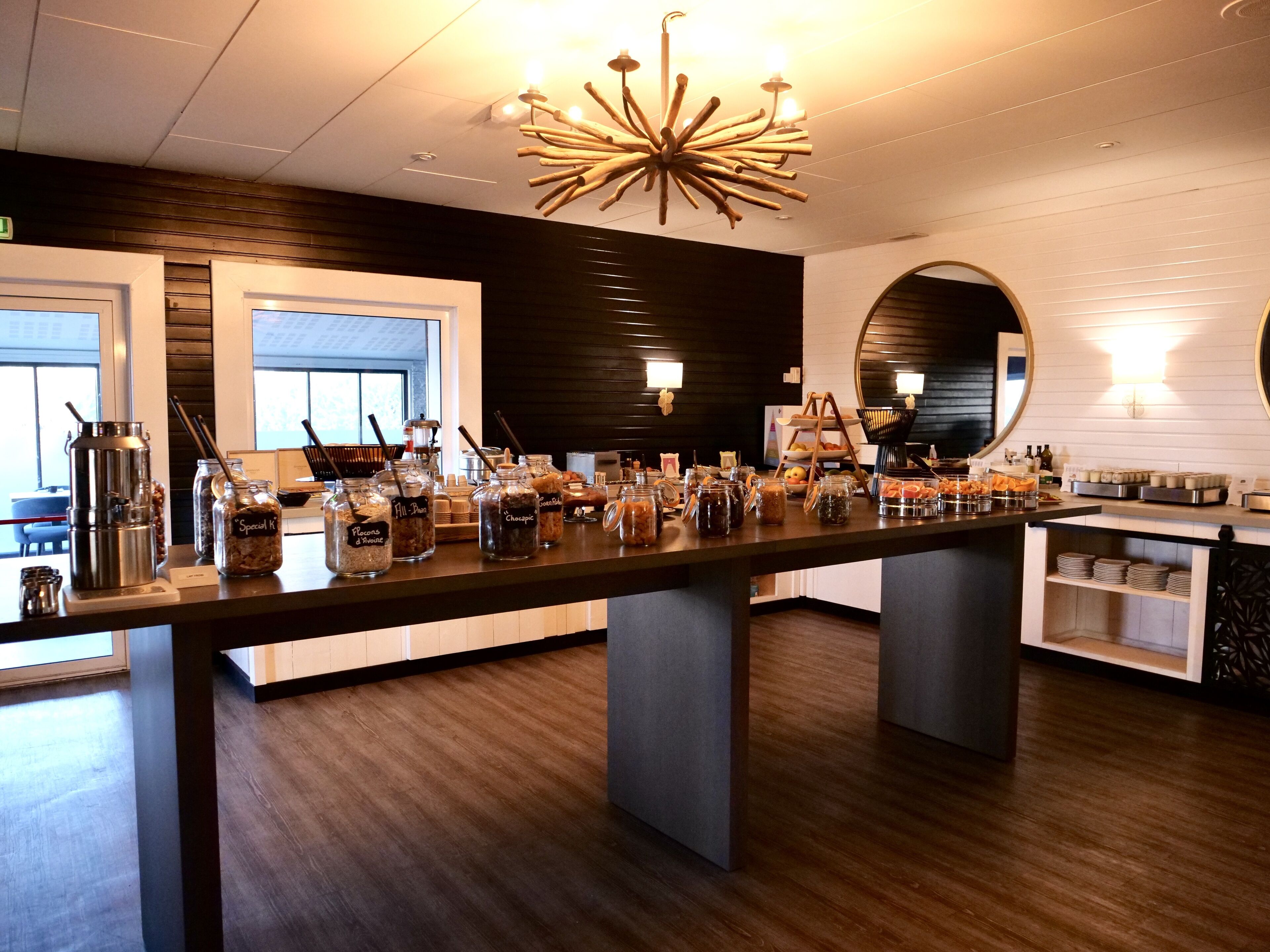 Een moderne café met een lange toonbank waarop verschillende gerechten en sauzen staan.