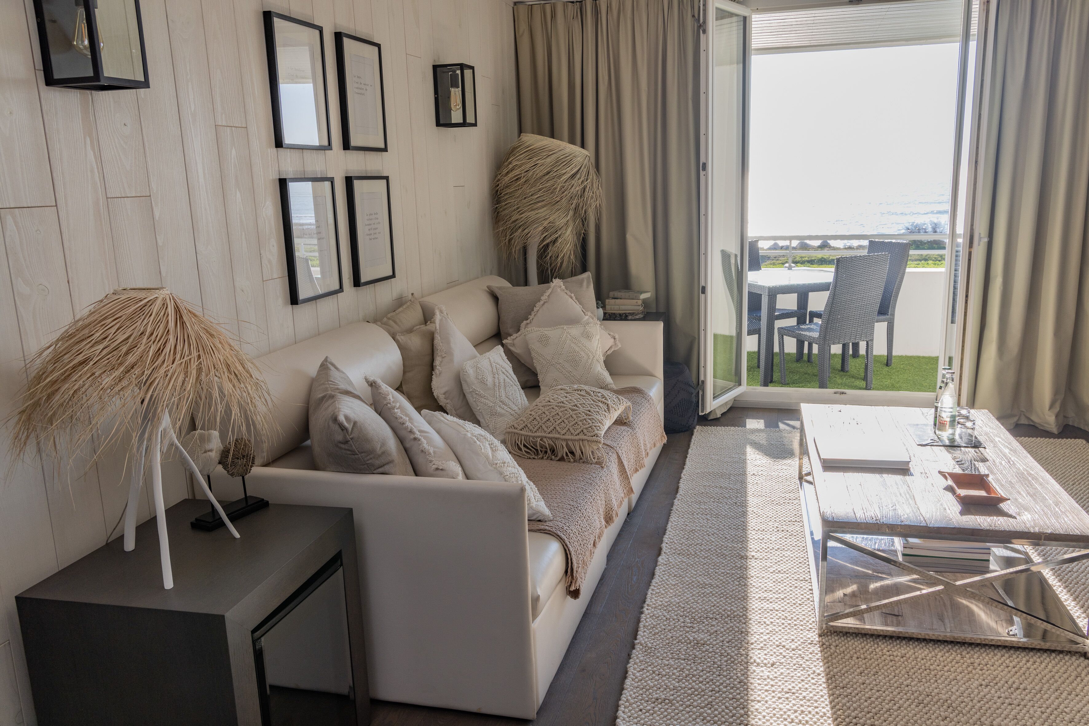 A modern living room with a sofa, coffee table, and a view of the outdoors.
