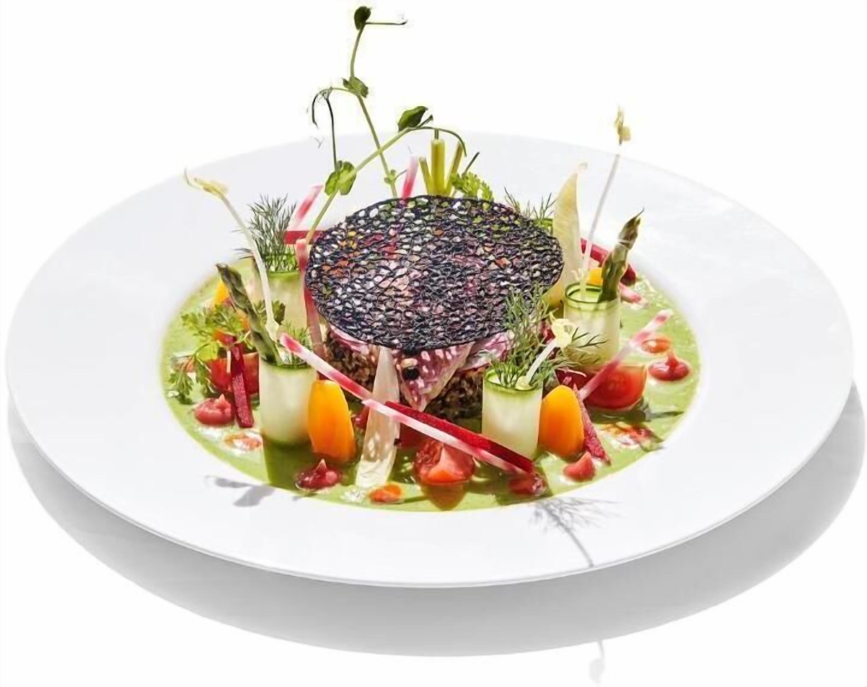 A white plate with a central dish surrounded by various vegetables and herbs.