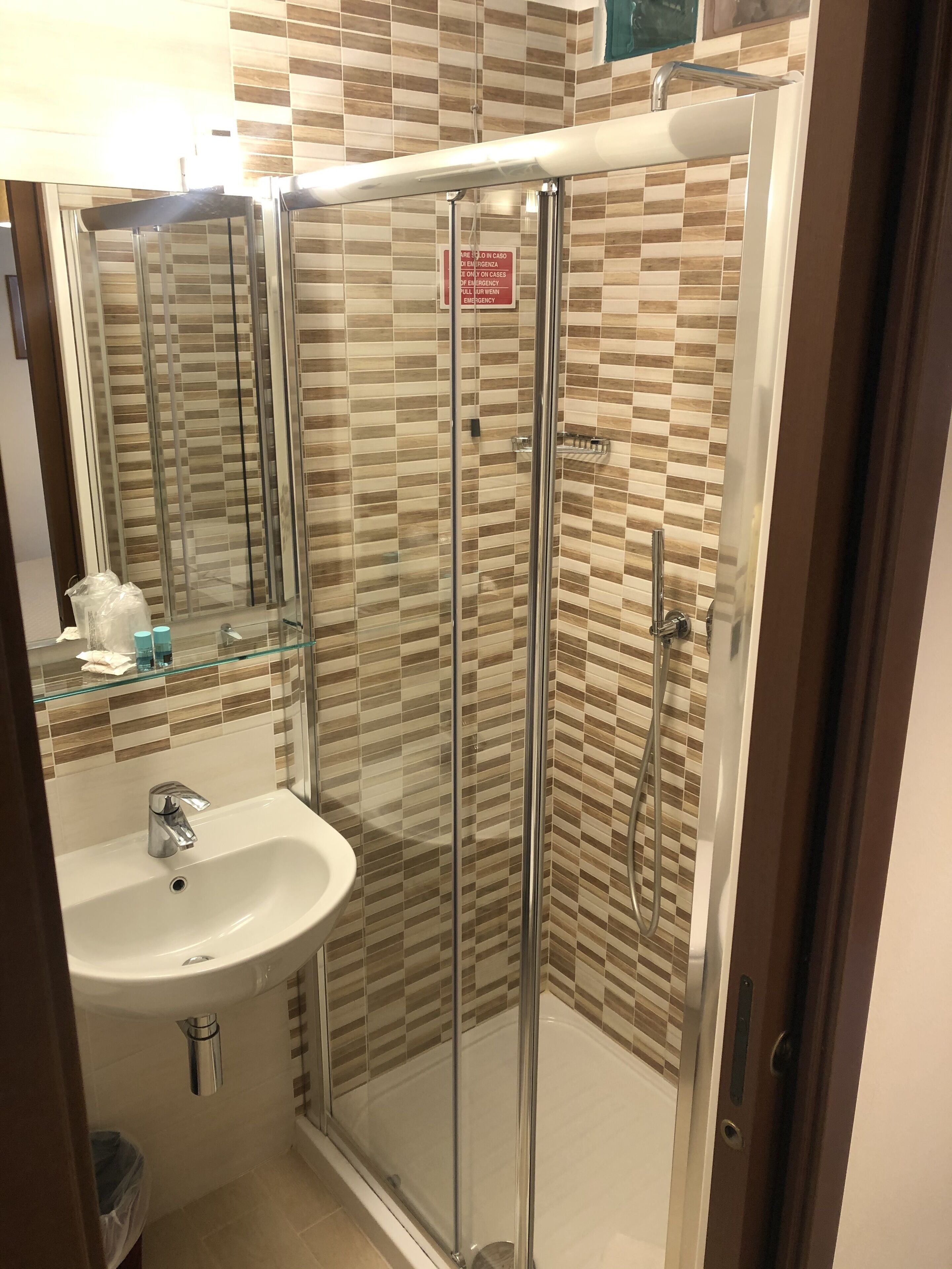 Une salle de bain avec une douche à parois de verre, un lavabo et un miroir.