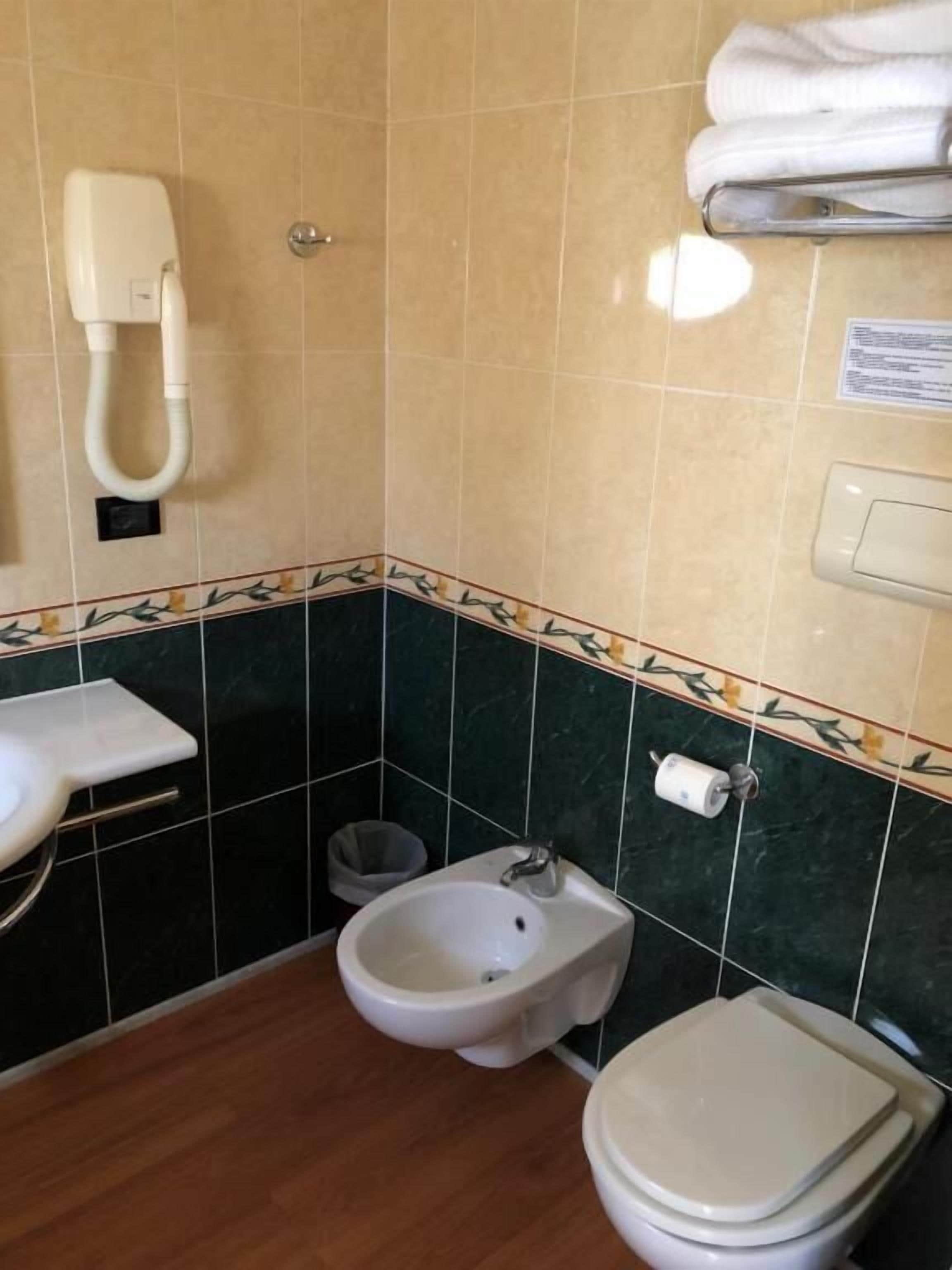 Ein kleines Badezimmer mit Toilette, Bidet und Waschbecken.