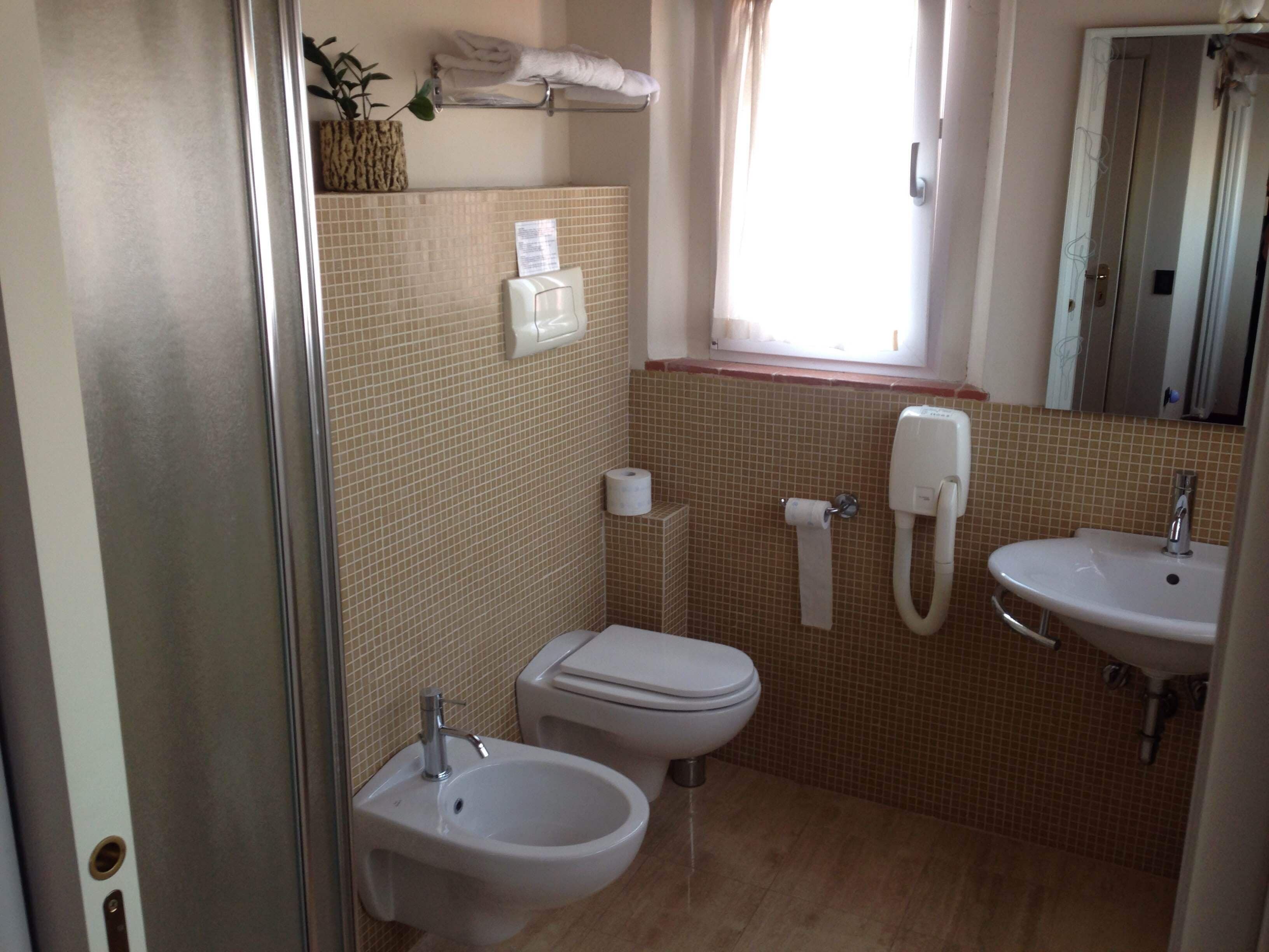 A bathroom with two sinks, a toilet, and a shower.