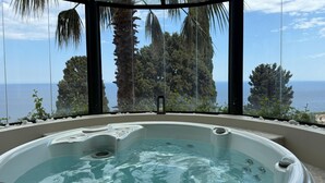 Un jacuzzi con vistas al mar y árboles.
