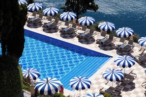 A poolside area with multiple lounge chairs and blue and white striped umbrellas. - Grand Hotel San Pietro Taormina - Preferred Hotels & Resorts (Taormina)