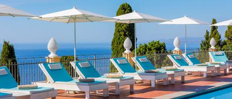 Een seizoensgebonden buitenzwembad, parasols voor strand/zwembad