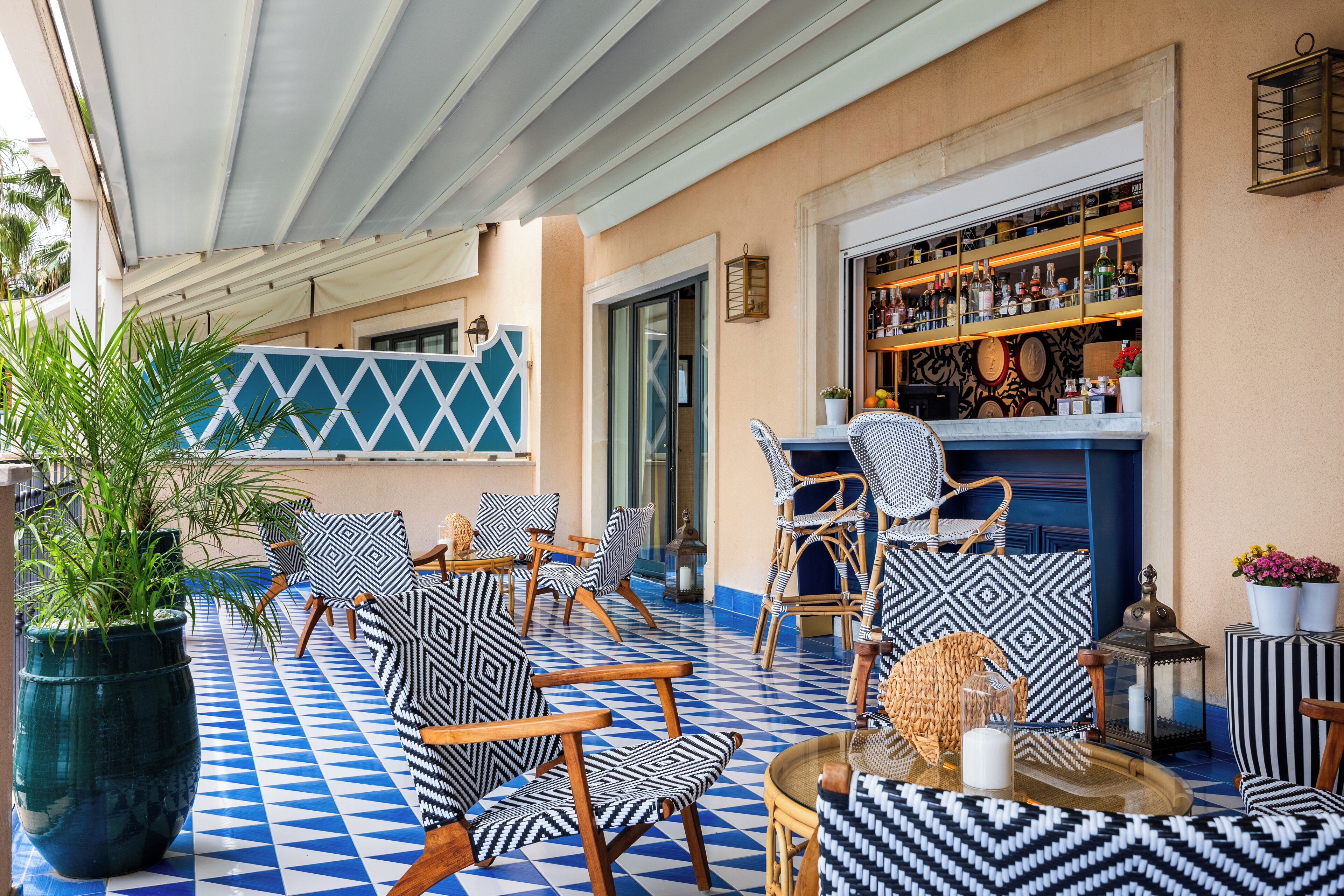 A bar area with patterned chairs and a blue and white tiled floor.