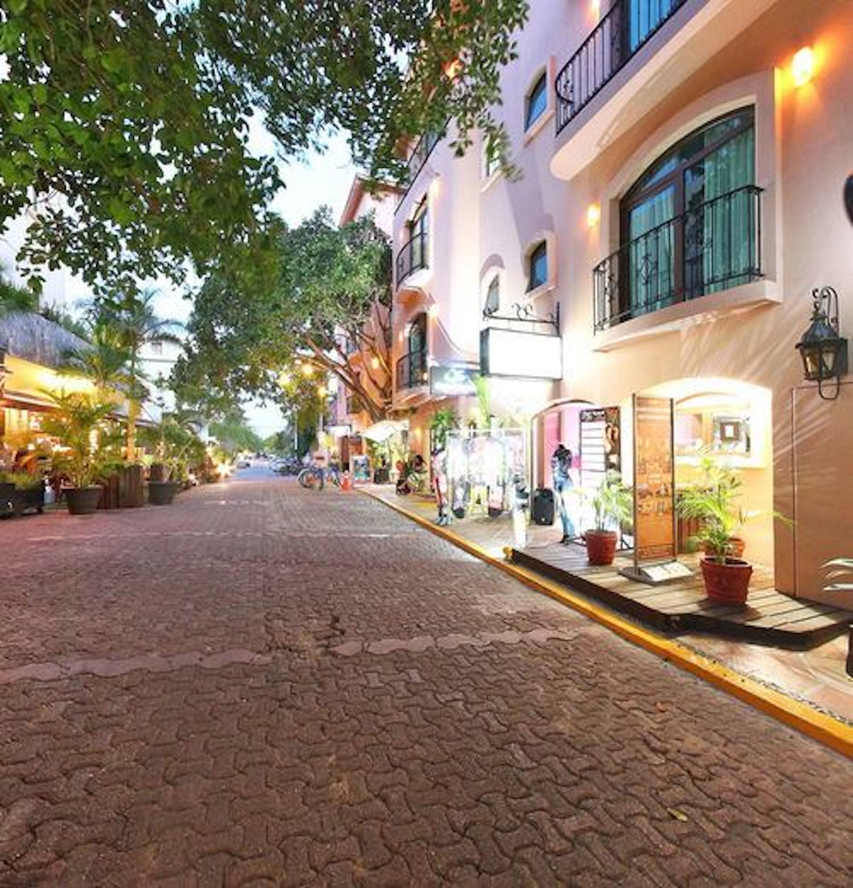 Una calle adoquinada flanqueada por edificios, algunos con balcones y terrazas.