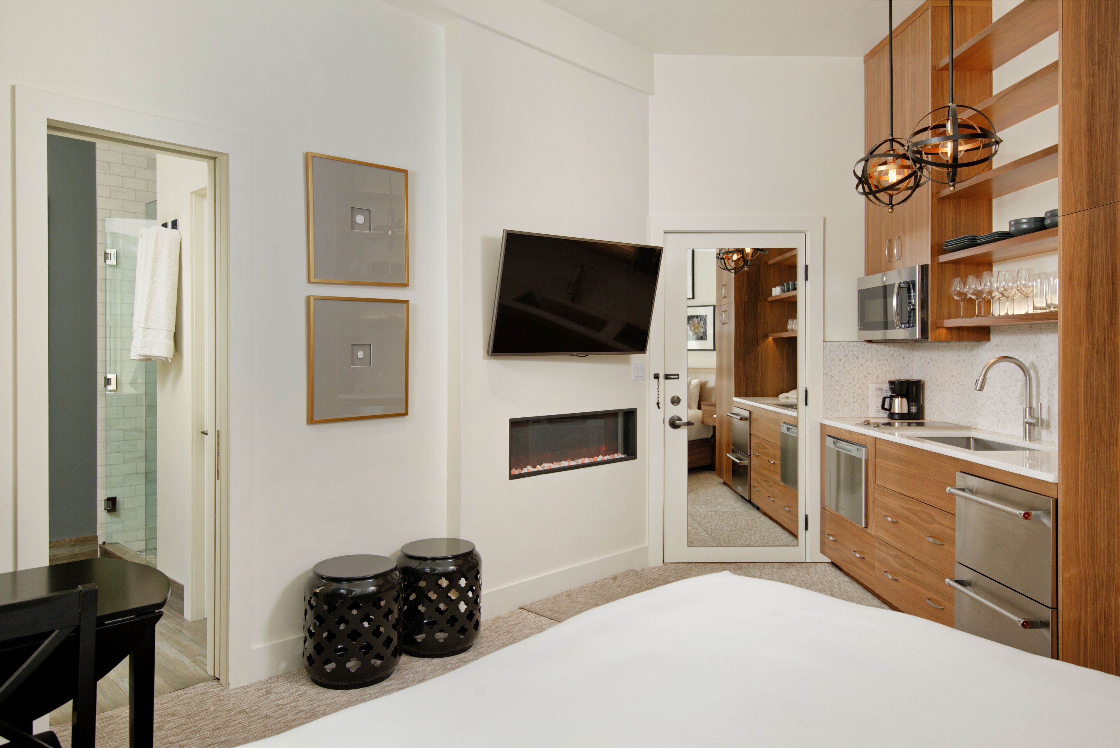 Una cocina moderna con microondas, horno y lavabo. Hay un televisor montado en la pared y una chimenea.