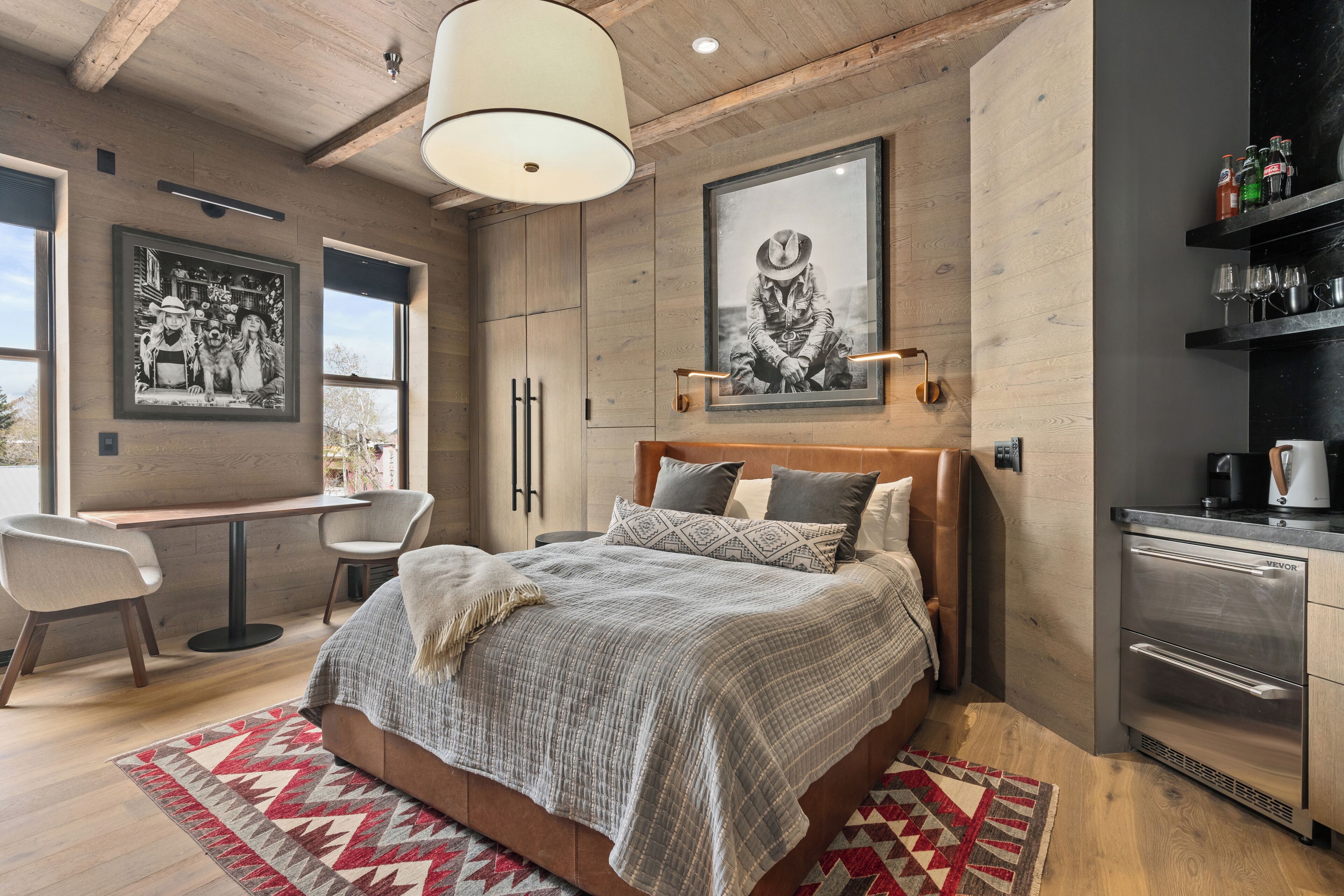 Een moderne slaapkamer met een groot bed, een bureau en een kitchenette.