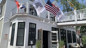 A white building with multiple flags, including the American flag, and a sign indicating VIP parking.