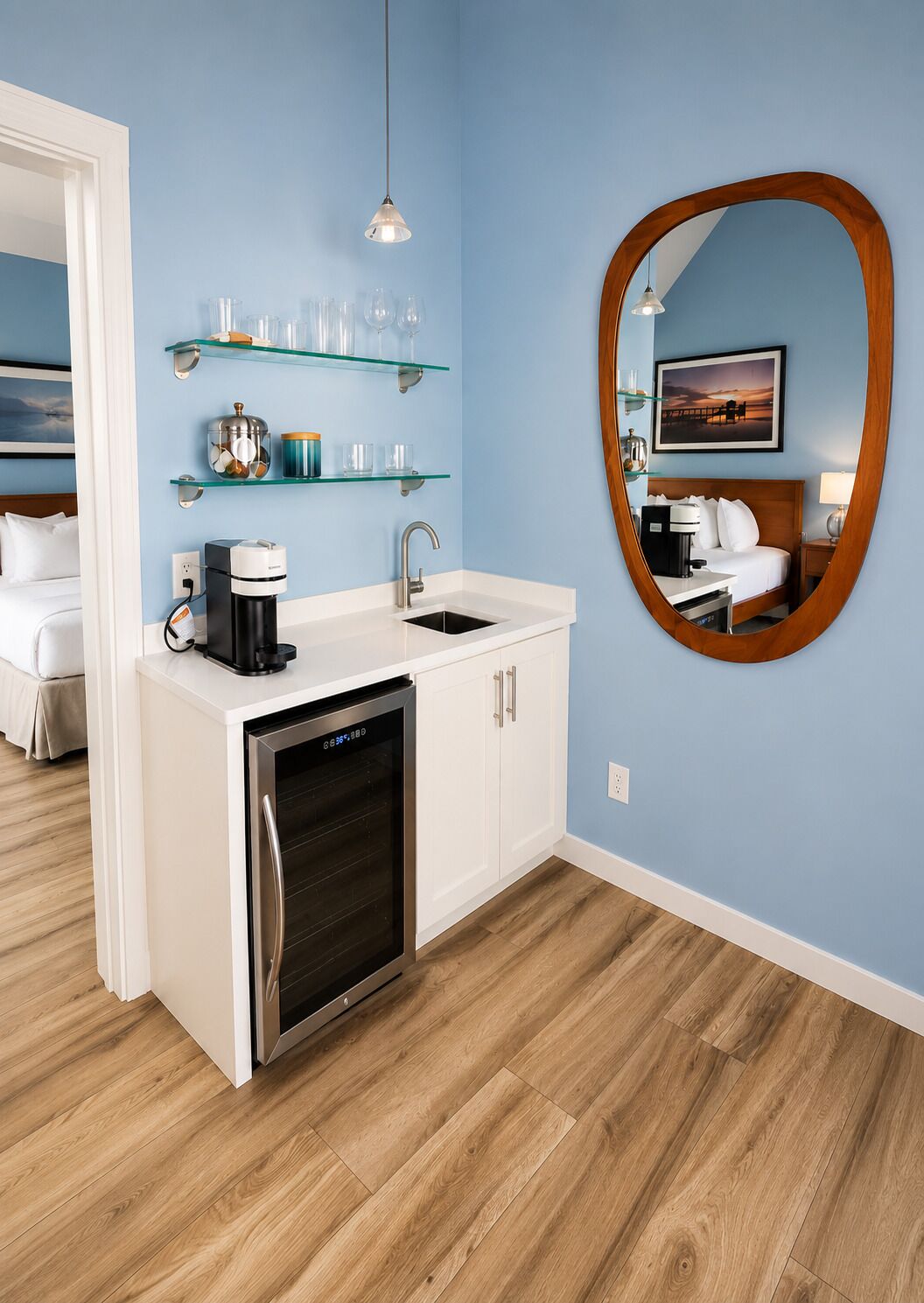 A modern kitchen with a built-in dishwasher, a coffee maker, and glass shelves above the sink.
