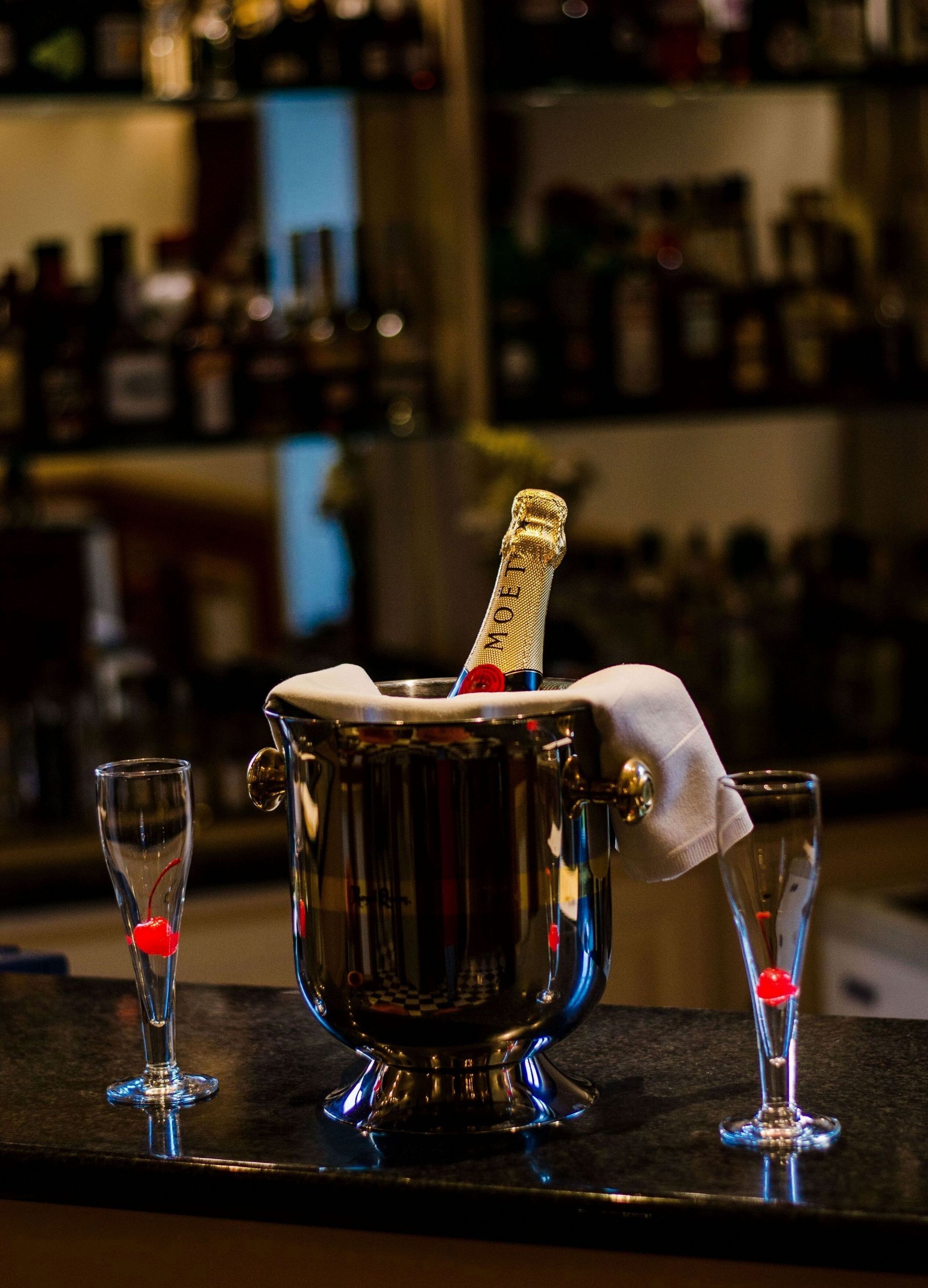 Un bar con un cubo de champán y dos copas.