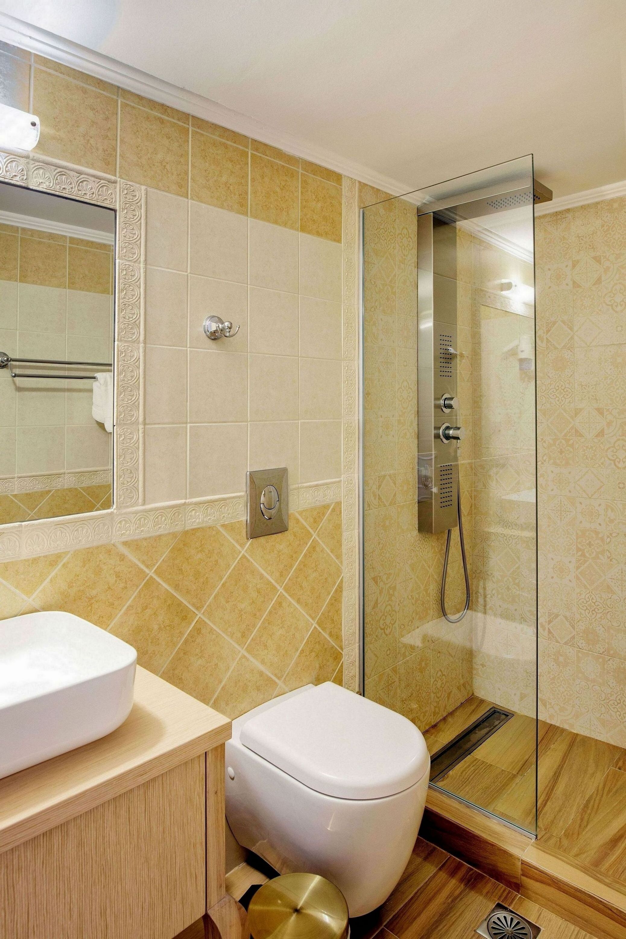 A modern bathroom with a glass-enclosed shower, a white toilet, and a sink with a beige countertop.