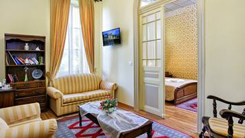 Una sala de estar acogedora con sofás a rayas, una mesa de centro de madera con un jarrón y una estantería.
