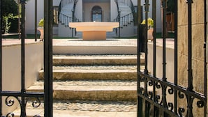 A hotel entrance with a wrought iron gate, a staircase leading to the main entrance, and a clear view of the building facade. - Halepa Hotel (Chania)