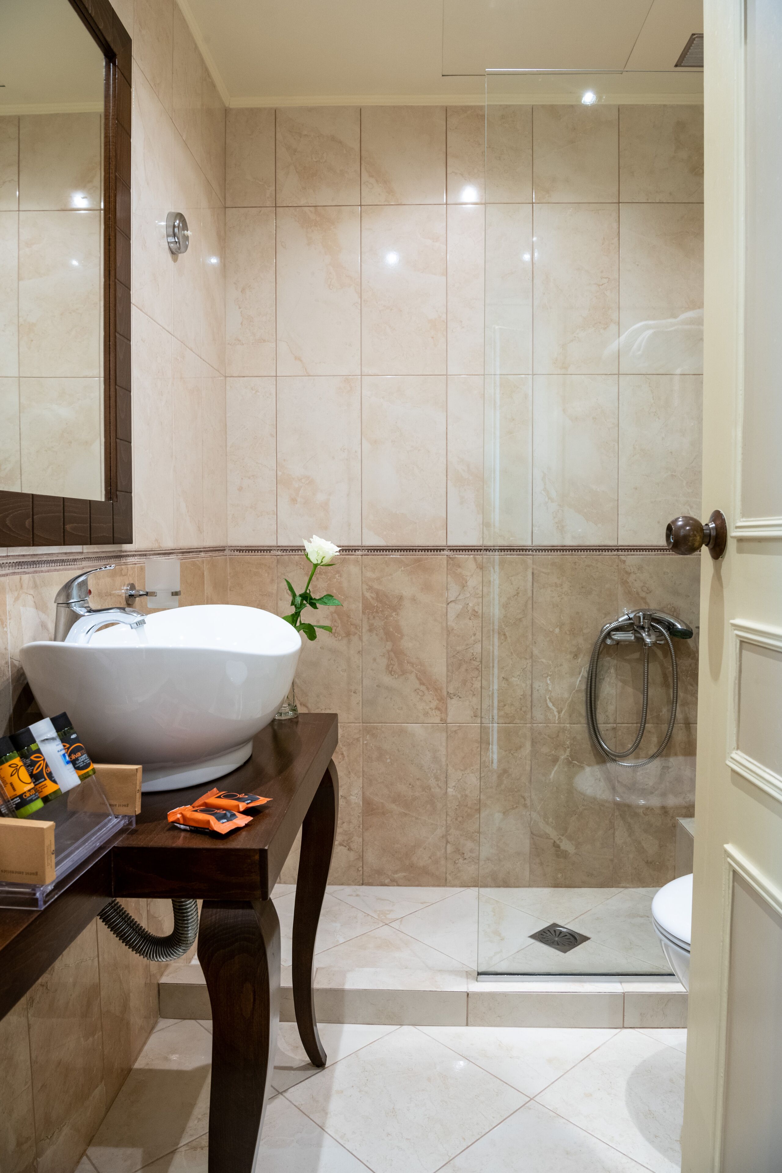 Un baño con un lavamanos grande de color blanco, un espejo y una zona de ducha.