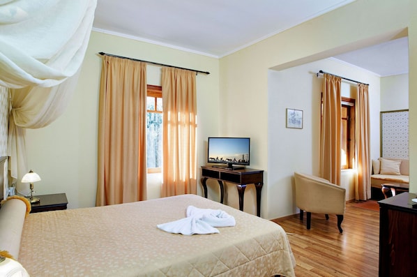A hotel room with a bed, a TV, a desk, a chair, and curtains.