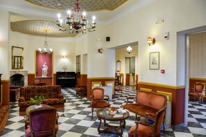 A hotel lobby with a checkered floor, ornate chandeliers, and classic furniture. - Halepa Hotel (Chania)