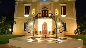 A hotel with a grand entrance, a central staircase, and a fountain in the foreground. - Halepa Hotel (Chania)