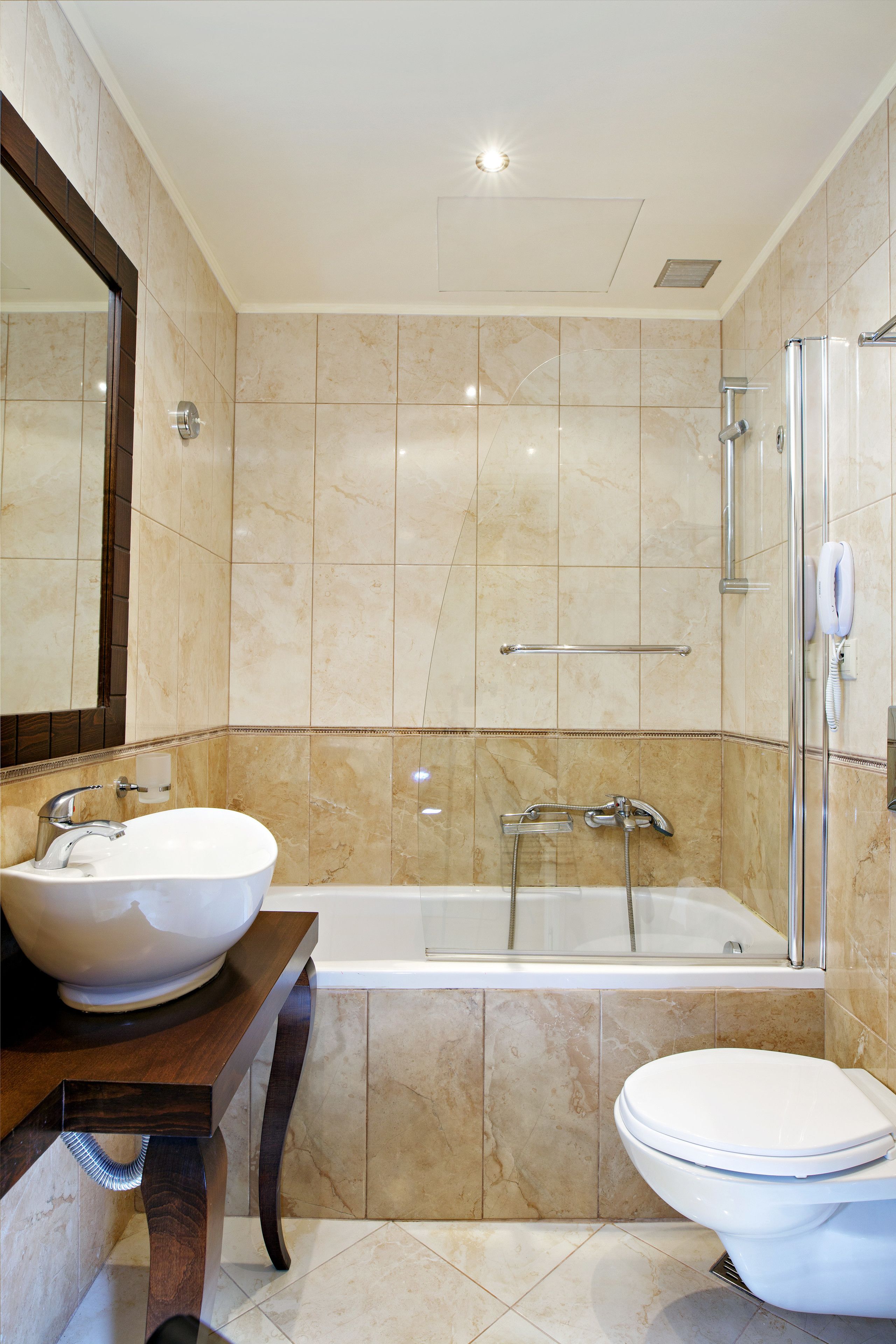 A modern bathroom with a large bathtub, a sink, and a toilet.