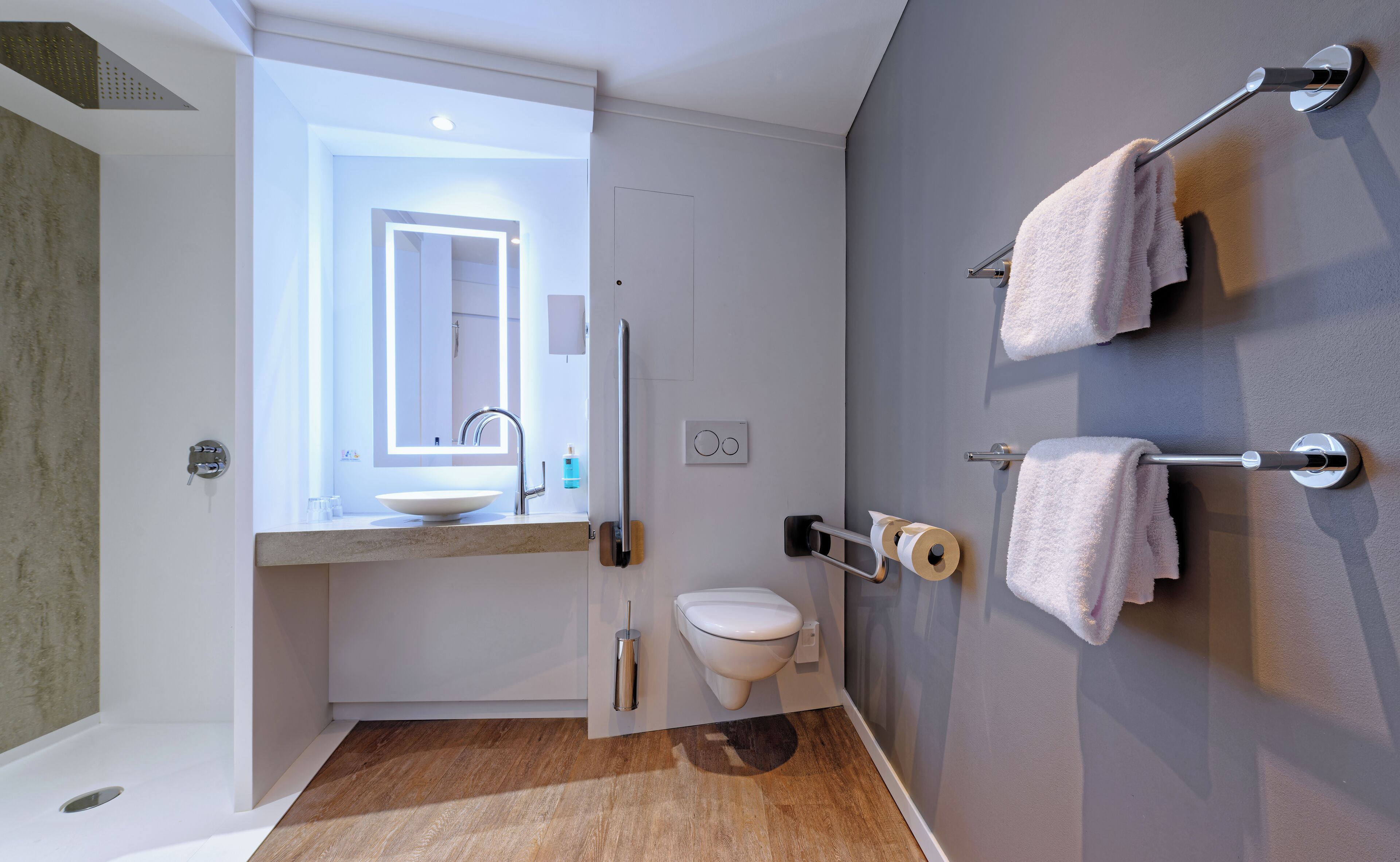 Ein modernes Badezimmer mit Waschtisch, WC und Handtuchhalter.
