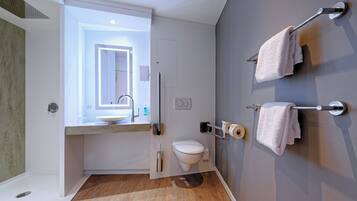 Ein modernes Badezimmer mit Waschtisch, WC und Handtuchhalter.